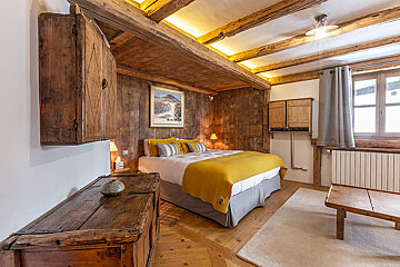 A bedroom with a bed and a painting on the wall