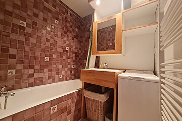 A bathroom with a sink and a washing machine