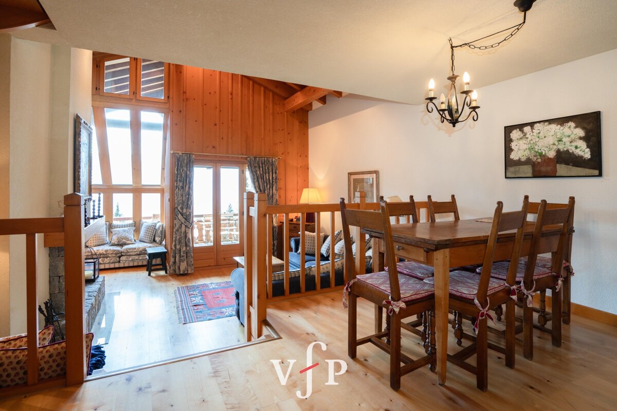 A living room with a wooden table and chairs and a sign that says vjp