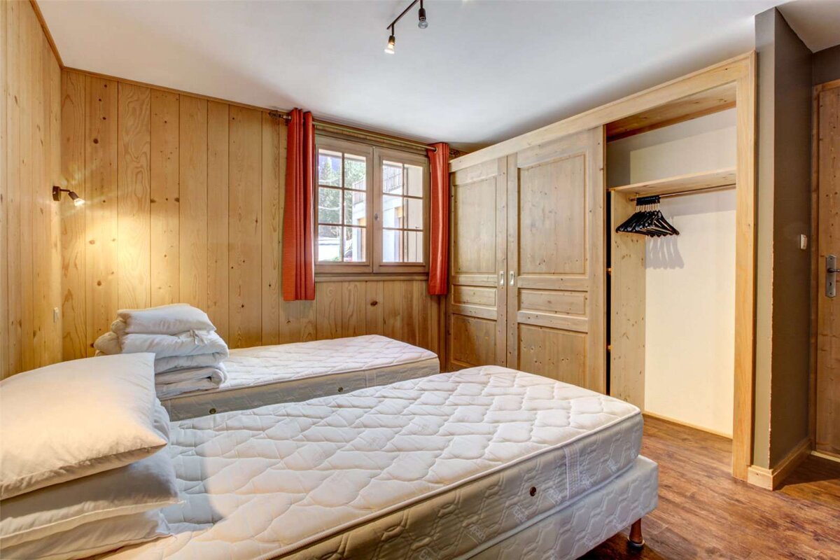 A bedroom with two beds and a closet