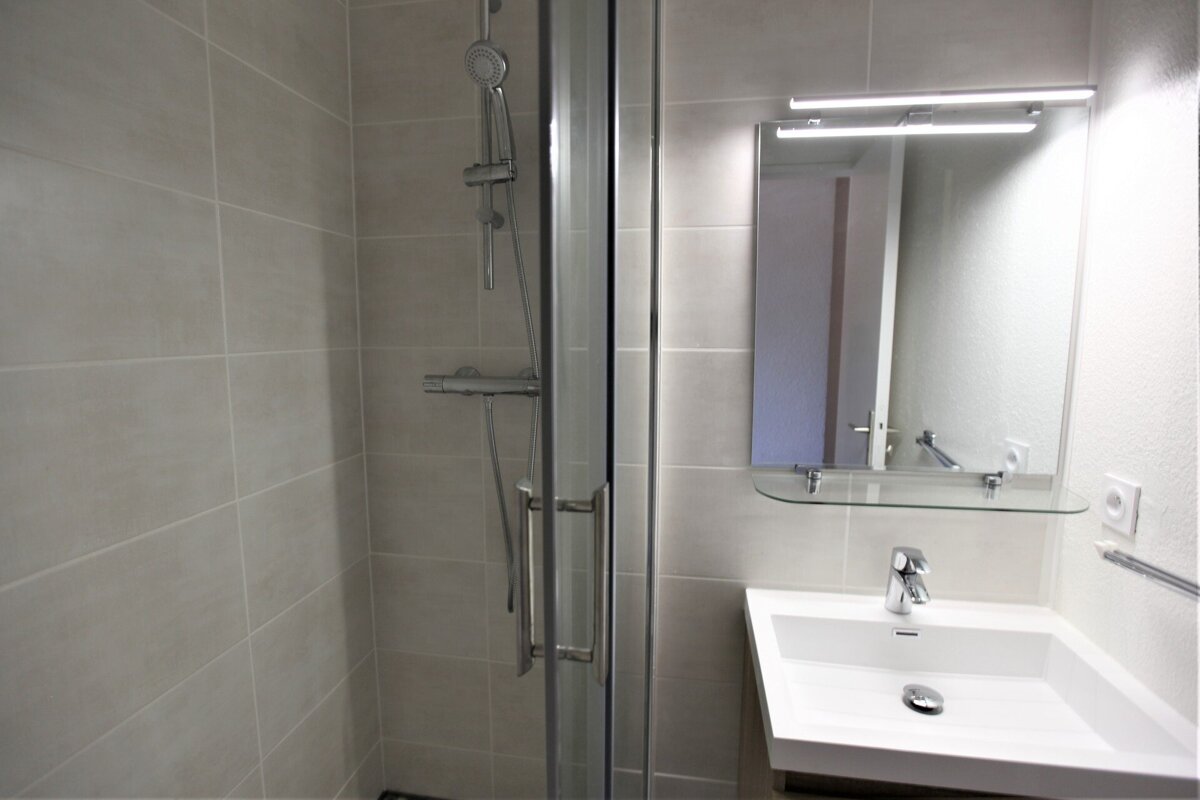 A bathroom with a sink and a shower stall