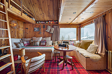 A wooden room with a couch and a table