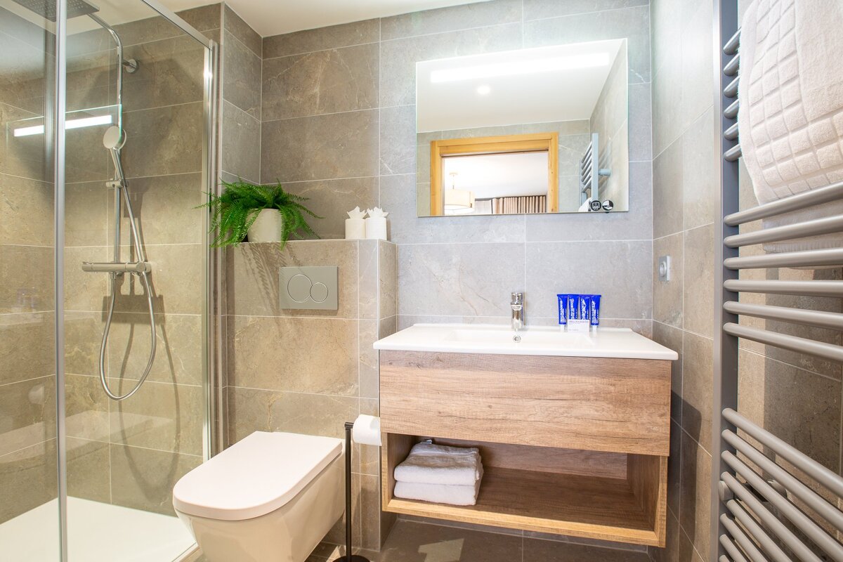 A bathroom with a toilet a sink and a mirror