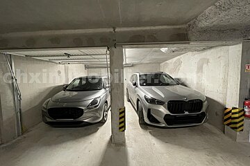 A bmw and a mercedes are parked in a garage