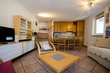 A living room with a table and chairs and a tv