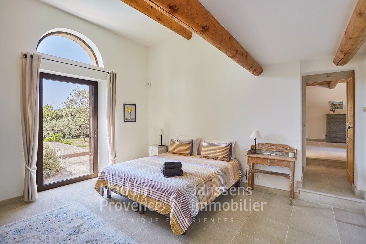 A bedroom with a bed and a door that says janssens immobilier