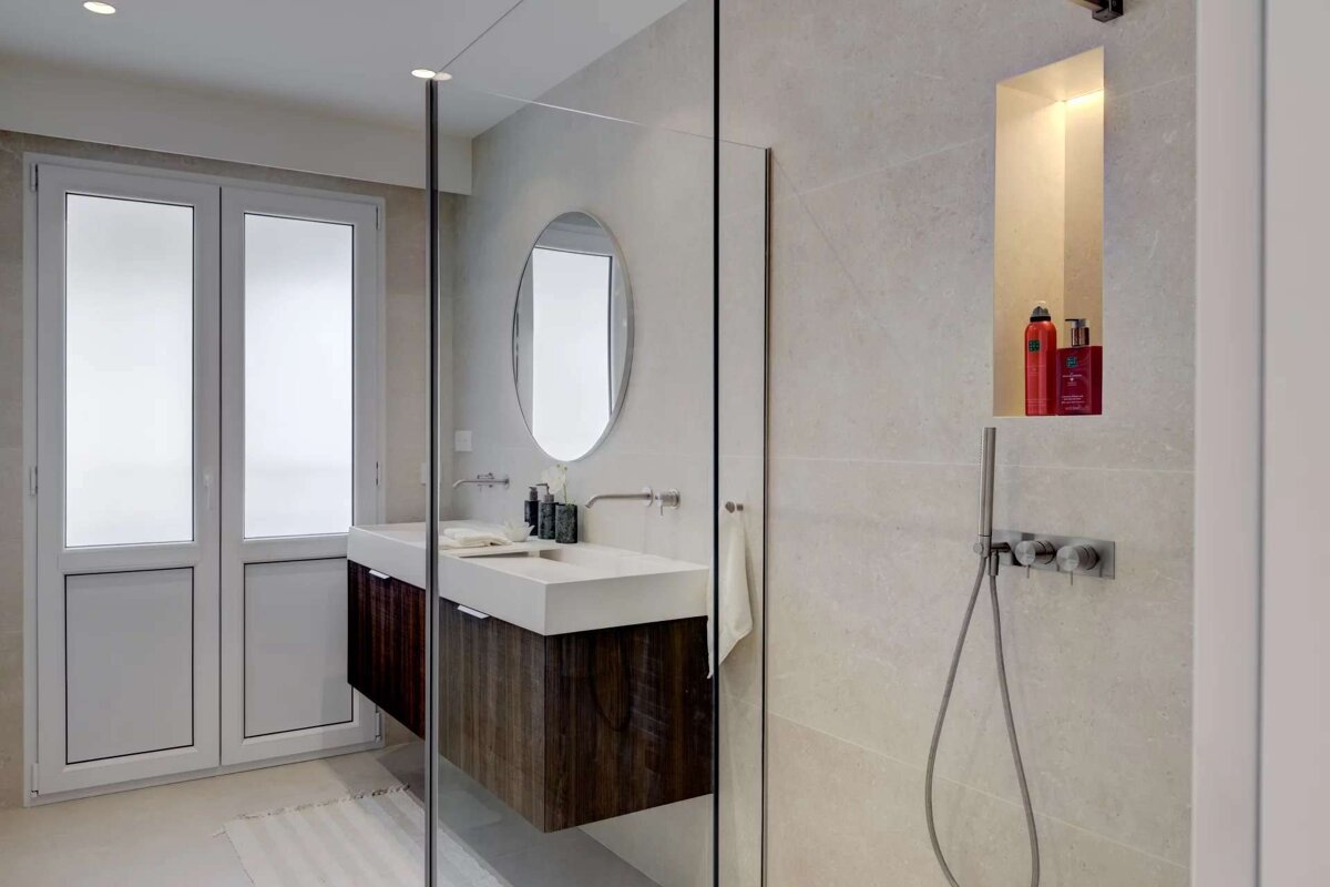 A bathroom with a walk in shower and two sinks