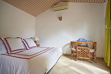 A bedroom with a bed and a table and chairs