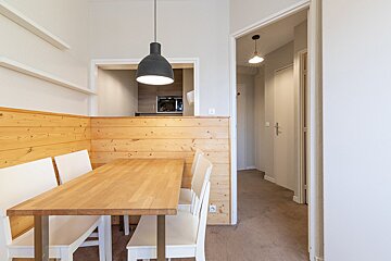 A dining room with a wooden table and white chairs
