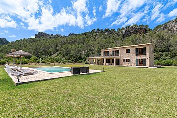 A large house with a swimming pool in front of it