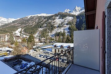 A balcony with a view of a snowy mountain range