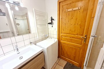 A bathroom with a washing machine and a sink