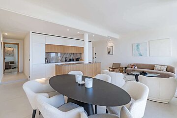 A dining room with a black table and white chairs