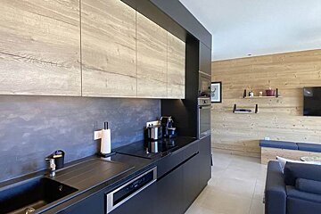 A kitchen with black cabinets and a soap dispenser on the counter
