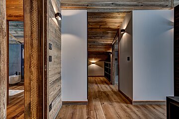 A hallway in a house with wooden walls and floors