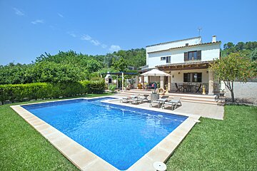 A house with a large swimming pool in front of it