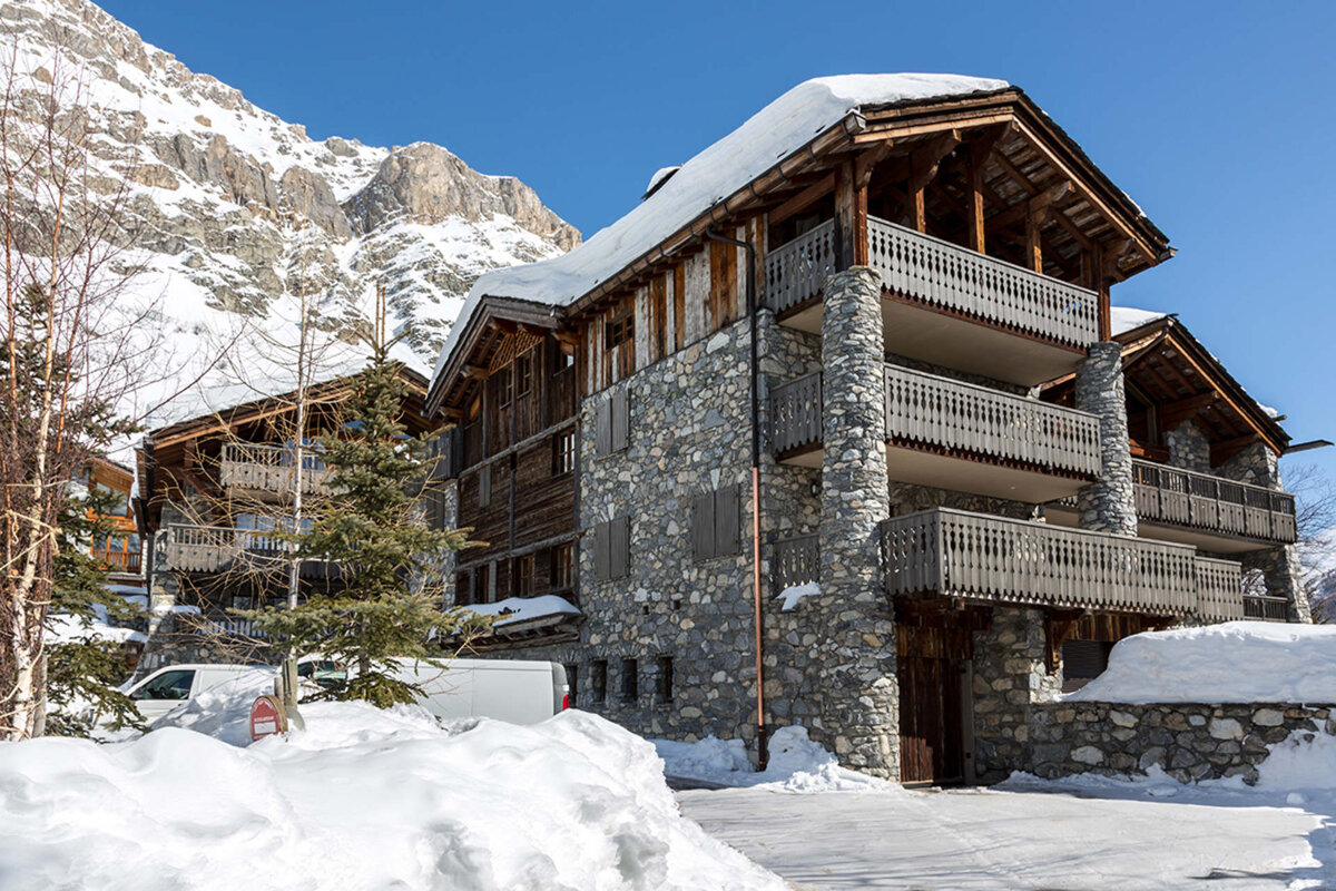 A snowy house with a blue sky in the background