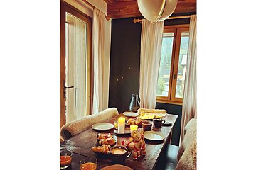 A wooden table with plates and candles on it