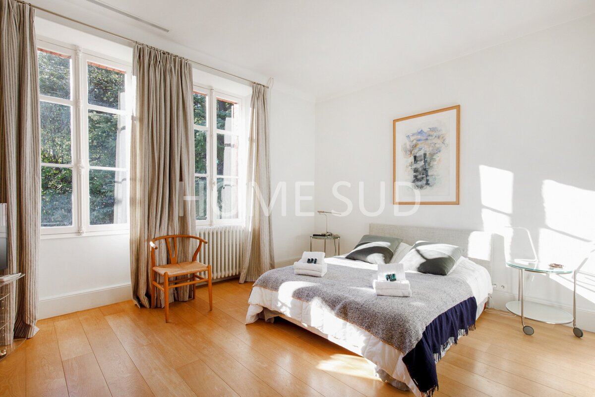 A bedroom with a large bed and a picture above it that says home sud