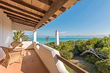 A balcony with a view of the ocean and a lighthouse