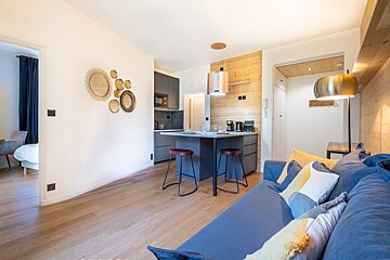 A living room with a couch and a kitchen