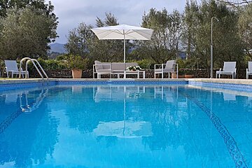 A swimming pool with a white umbrella in the middle