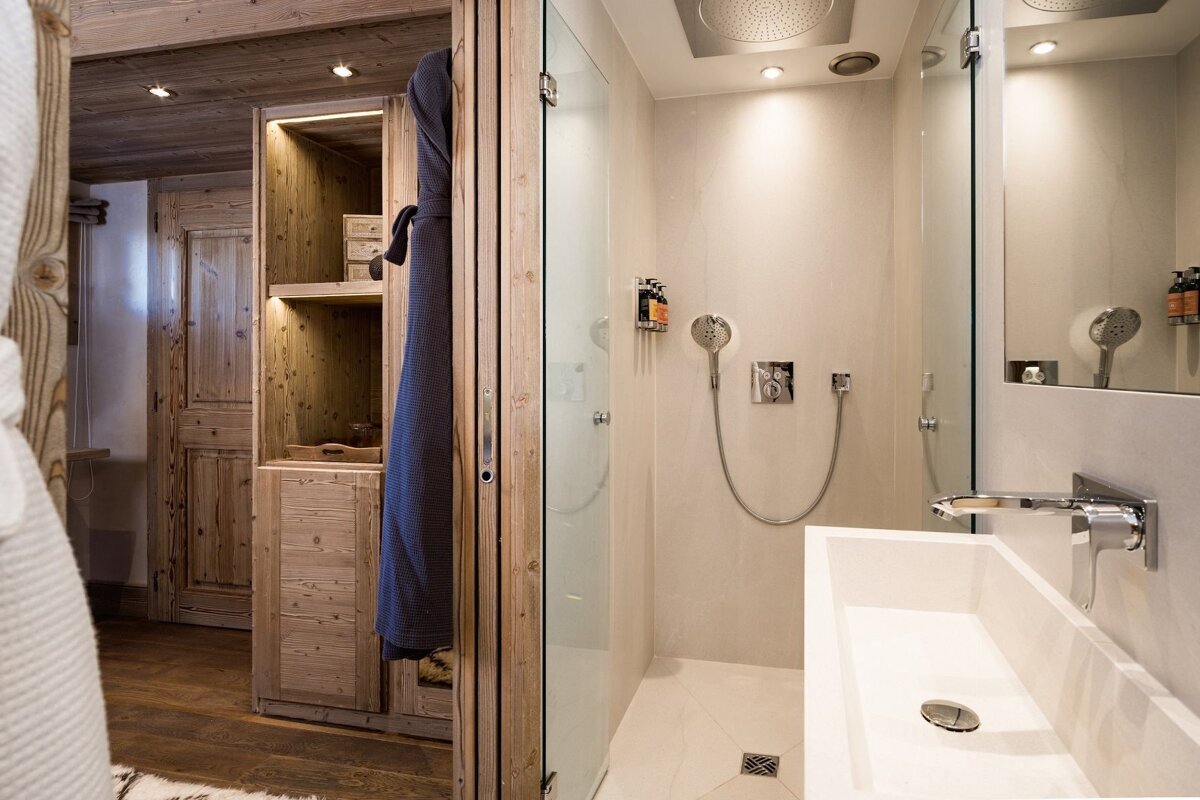 A bathroom with a walk in shower and a sink