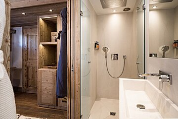 A bathroom with a walk in shower and a sink