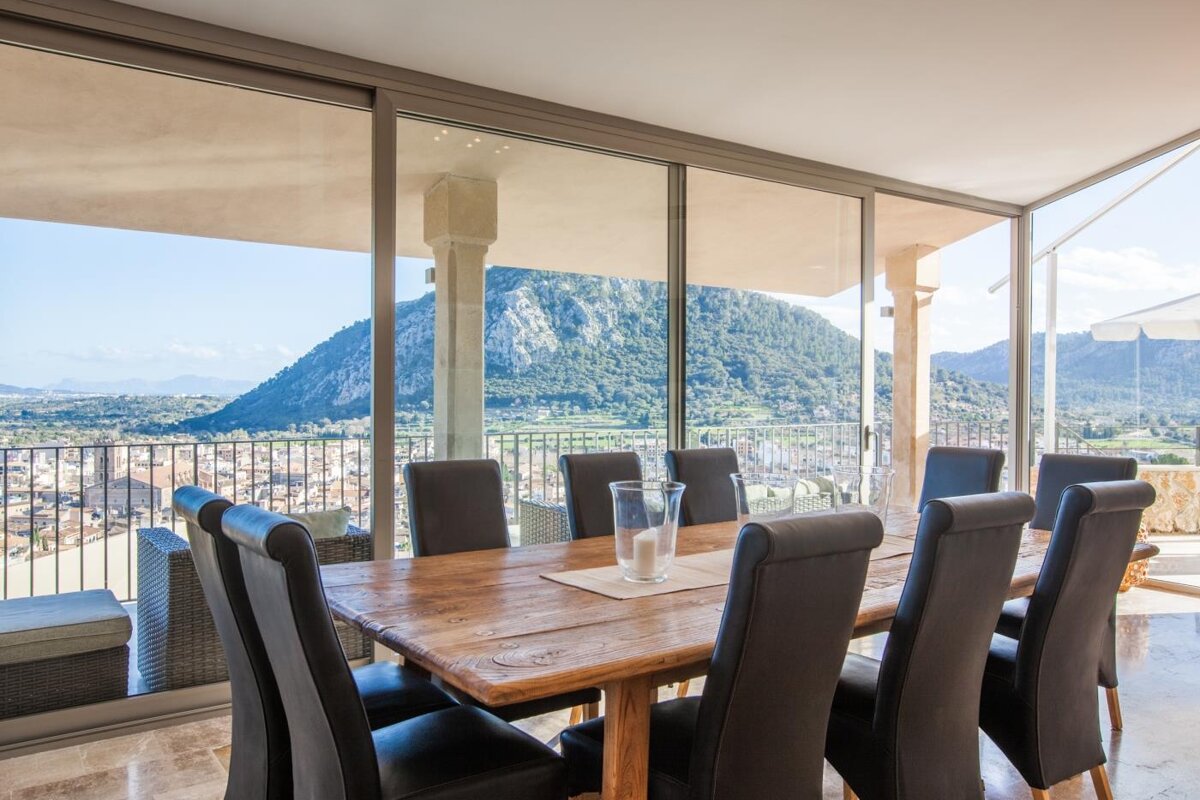A dining room table and chairs with a view of a mountain