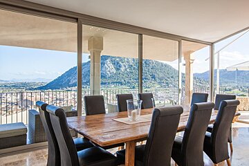 A dining room table and chairs with a view of a mountain