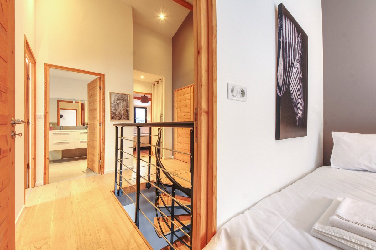 A bedroom with a staircase and a picture of a zebra on the wall