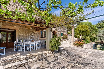 A stone house with a table and chairs outside
