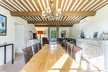 A dining room with a wooden table and chairs and a striped ceiling
