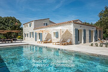 A large stone house with a large swimming pool in front of it
