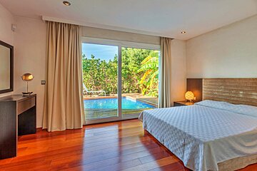 A bedroom with a sliding glass door leading to a swimming pool
