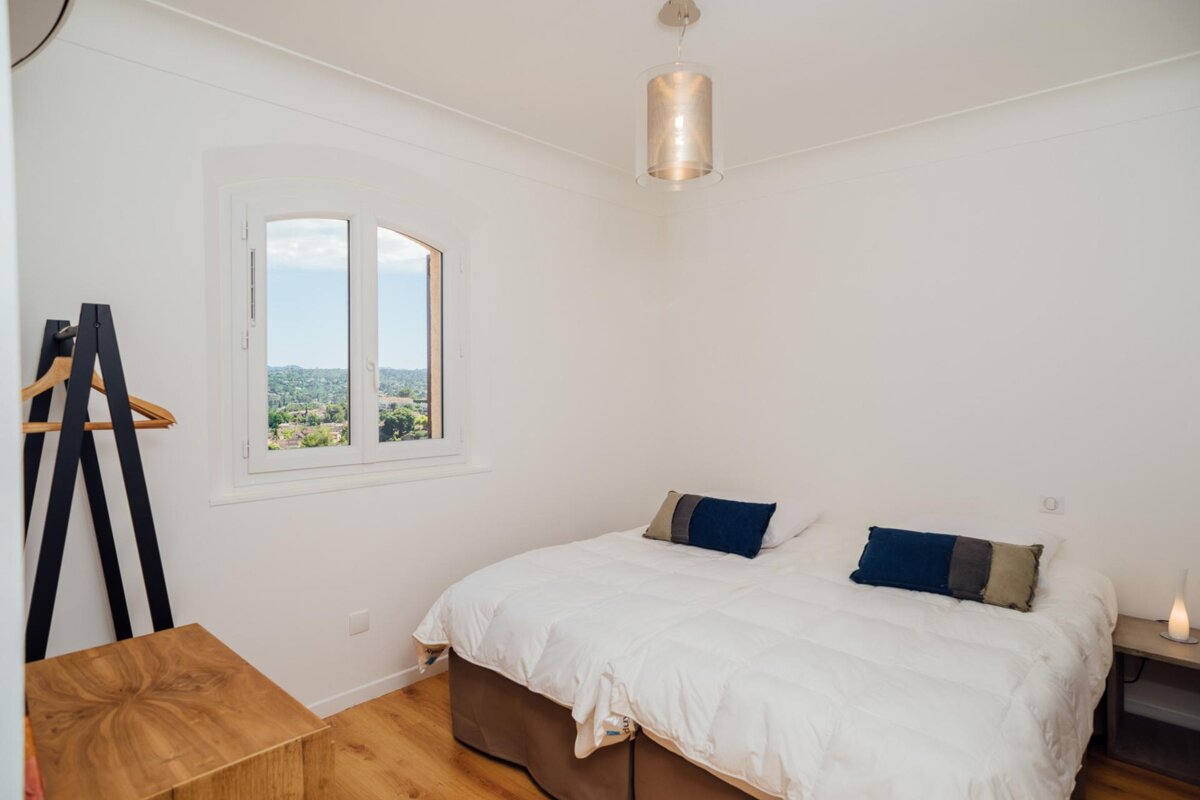 A small bedroom with a bed and a window