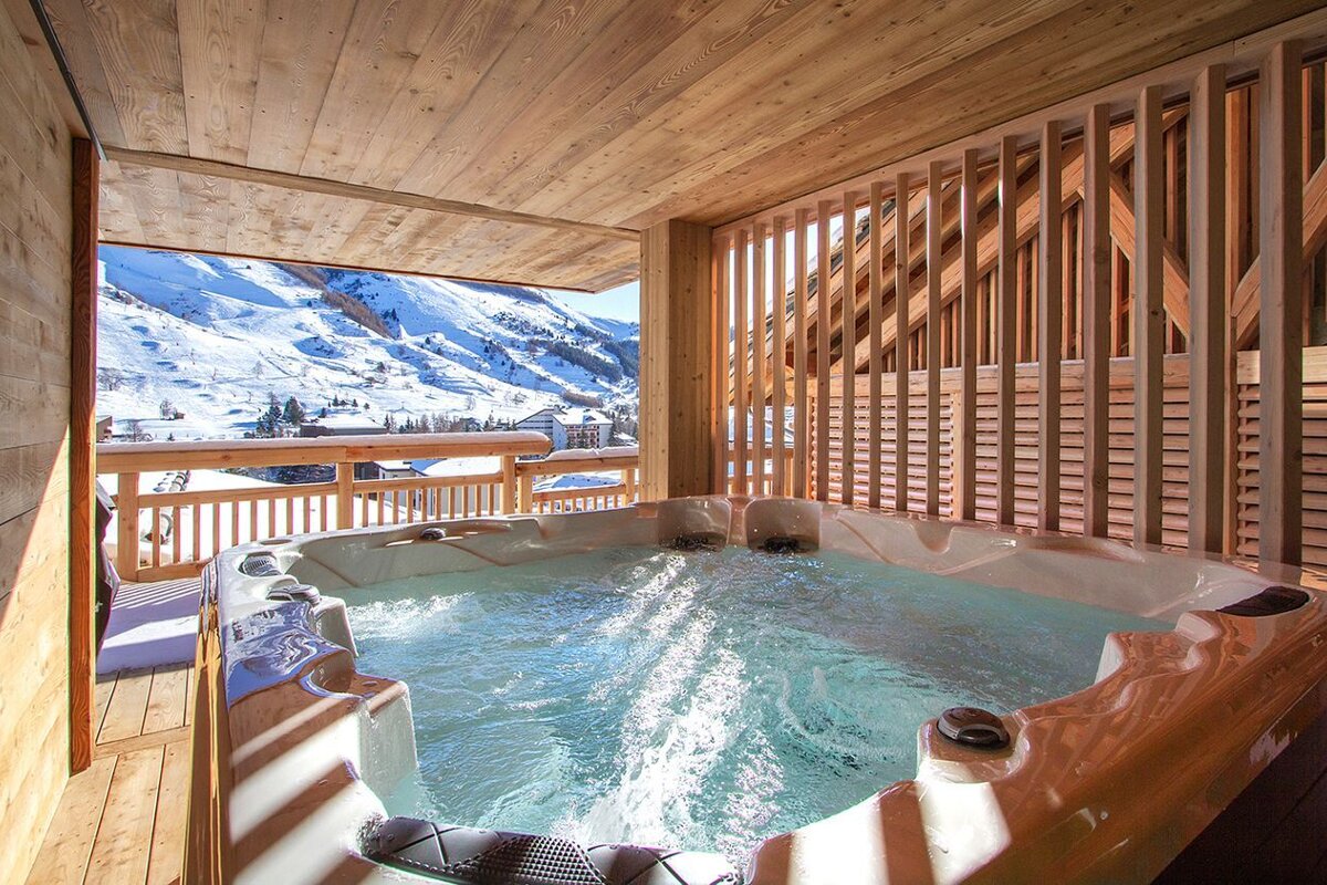 A hot tub with a view of snowy mountains in the background