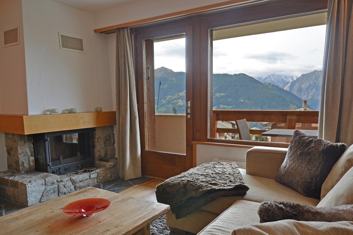 A living room with a fireplace and a view of mountains