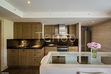 A kitchen with wooden cabinets and stainless steel appliances and the word tempo on the ceiling