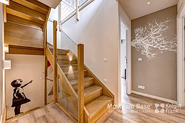 A staircase with a knight frank logo on the wall