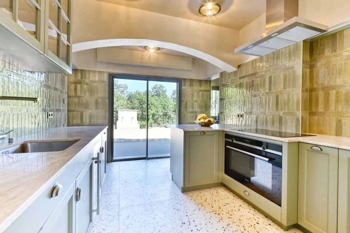A kitchen with green cabinets and a siemens oven