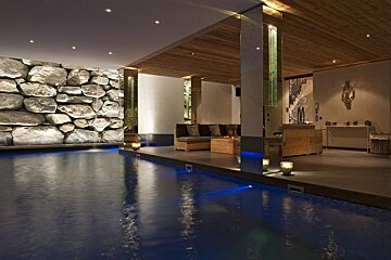 A large indoor pool with a stone wall behind it