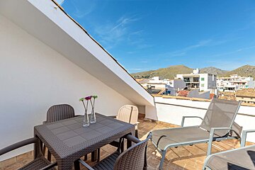 A table and chairs on a balcony overlooking a city