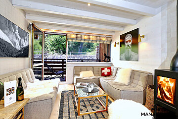 A living room with a couch that has a swiss cross on it