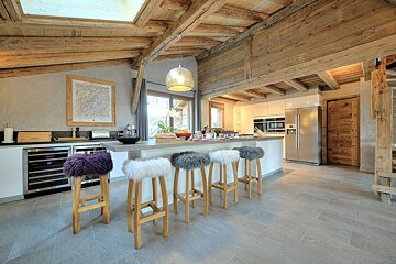 A kitchen with furry stools and a map on the wall