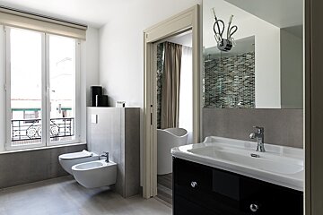 A bathroom with two toilets and a sink