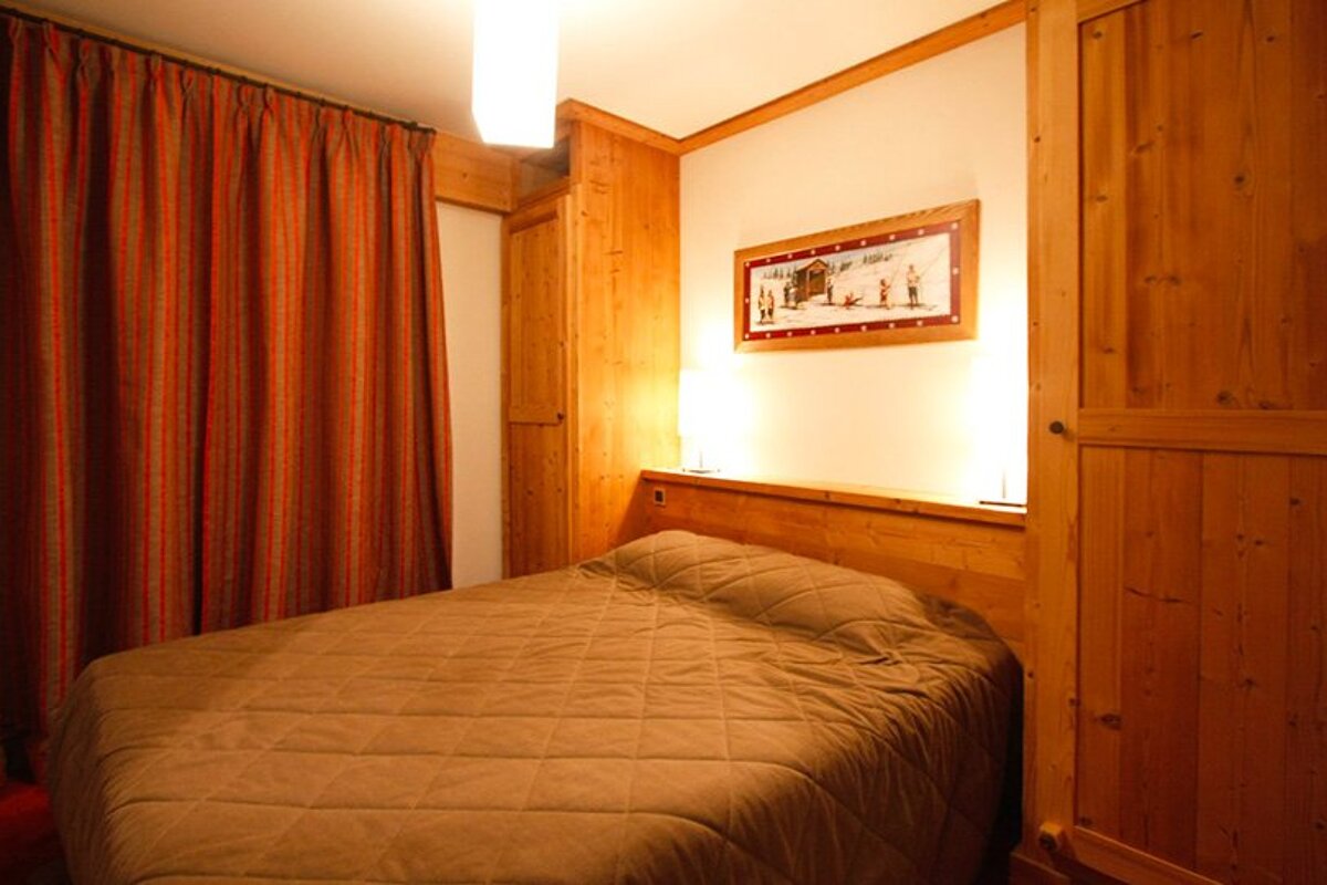 A bedroom with a bed and a picture on the wall