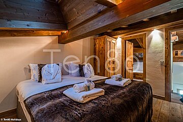 A bedroom with a bed and a sign that says ten80 holidays