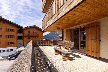 A balcony with a wooden bench and the letter v on it