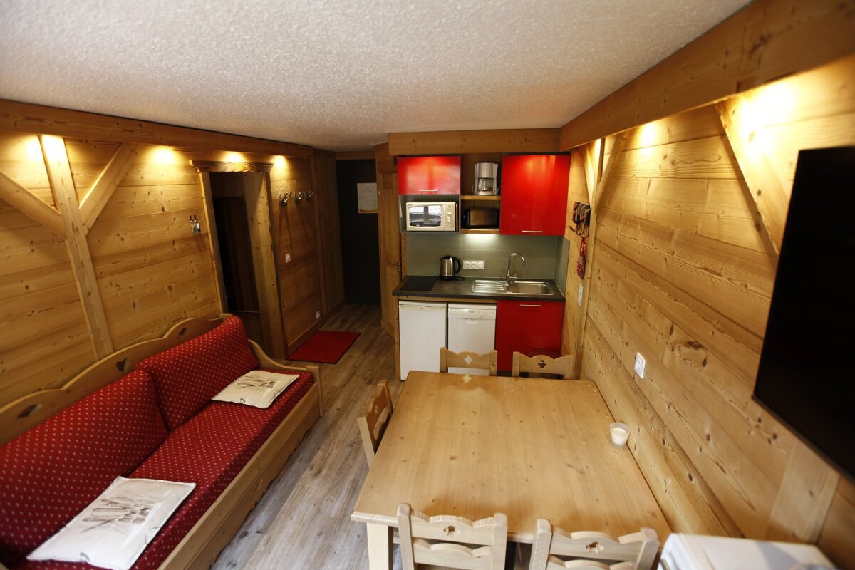 A kitchen with red cabinets and a table and chairs